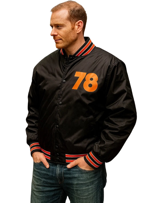 Man wearing a black jacket with orange number 78 on a white background