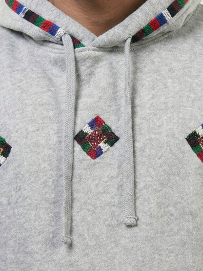 Gray hoodie with colorful diamond patterns on a plain background