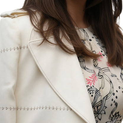 Close-up of a person wearing a white coat with a patterned scarf.