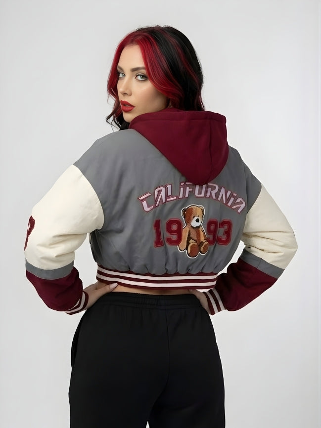 Person wearing a gray and red varsity jacket with 'California 1993' and a teddy bear design on a white background