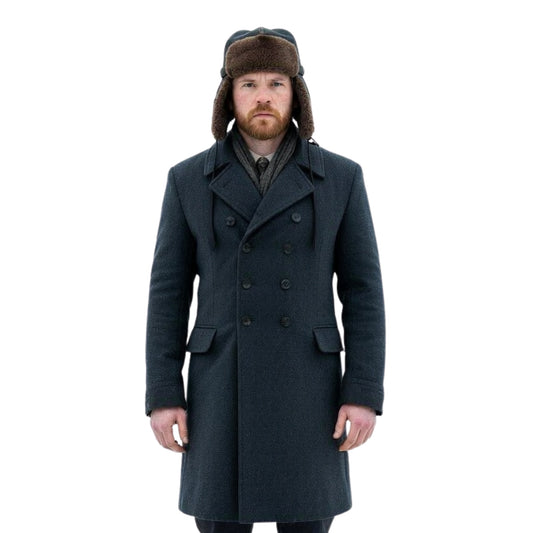 Man wearing a long dark coat and a fur-lined hat on a white background