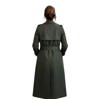 Person wearing a long green trench coat on a white background