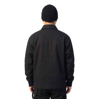 Person wearing a black jacket and beanie on a white background