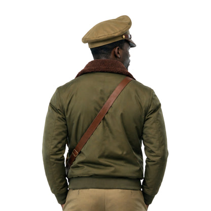 Person wearing a green jacket with a brown leather strap over a white background