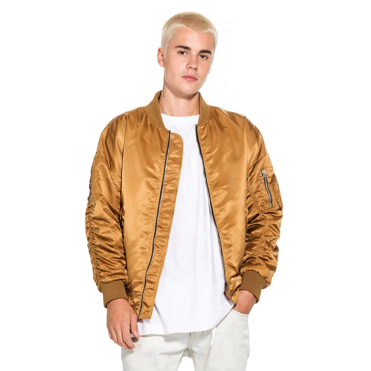 Person wearing a tan bomber jacket over a white shirt on a white background