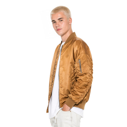 Person wearing a brown bomber jacket on a white background