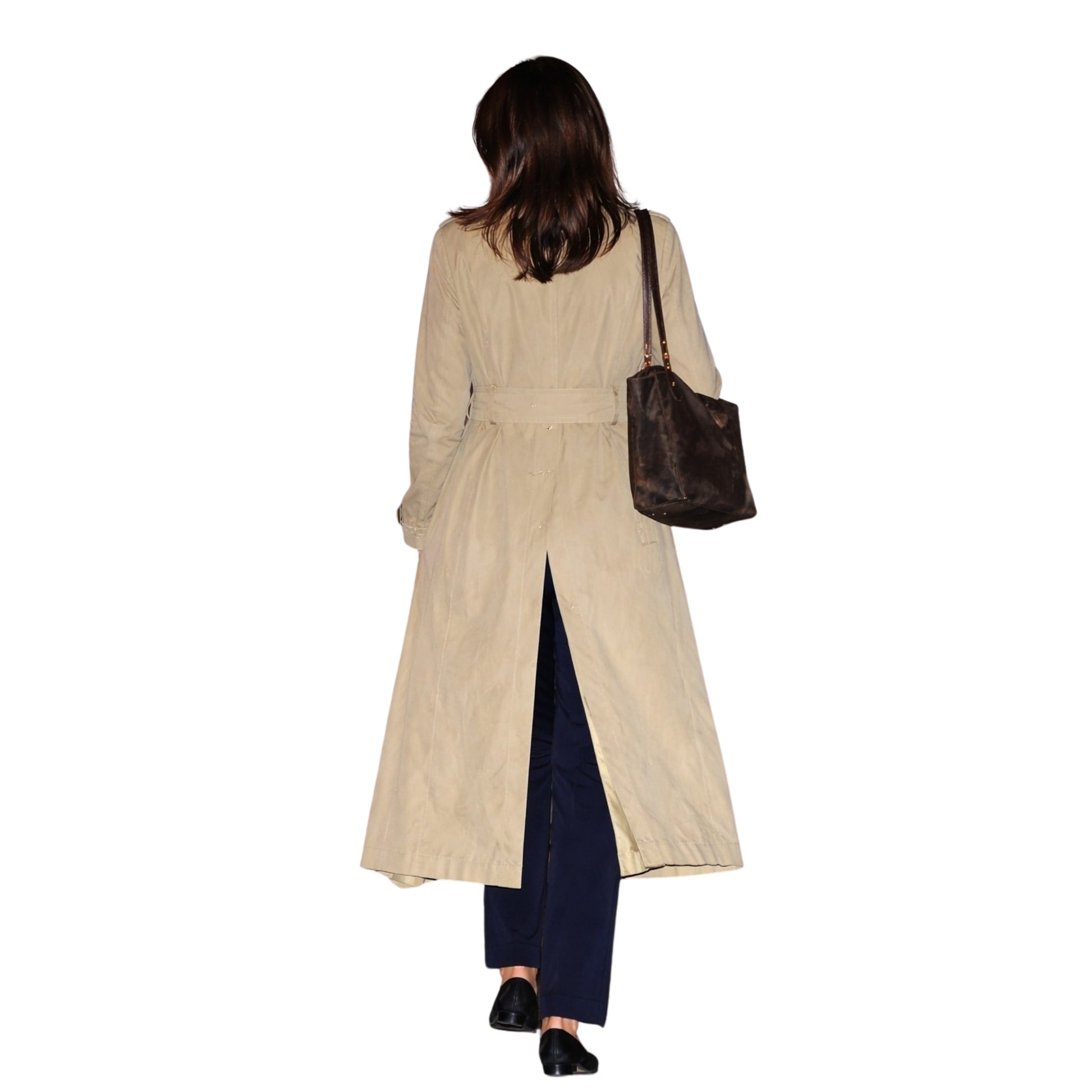 Woman wearing a beige trench coat and holding a brown handbag on a white background