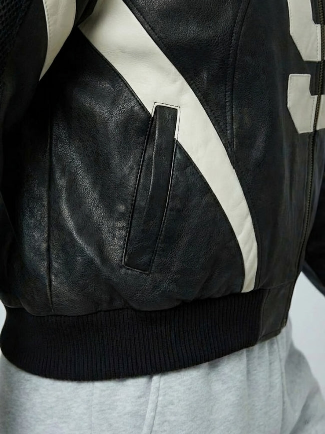 Close-up of a black leather jacket with white accents on a white background