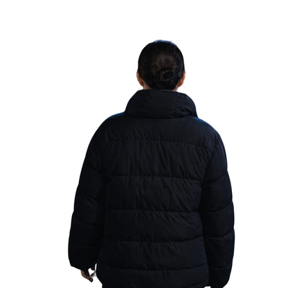 Person wearing a black puffer jacket on a white background