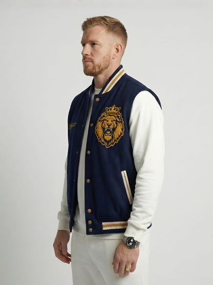 Man wearing a navy blue letterman jacket with a lion emblem on a white background