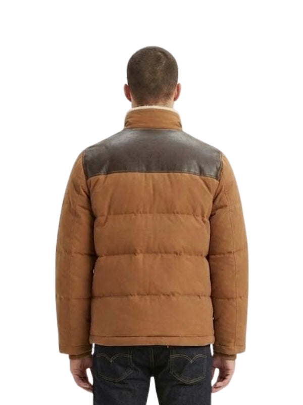 Man wearing a brown puffer jacket with leather accents on a white background