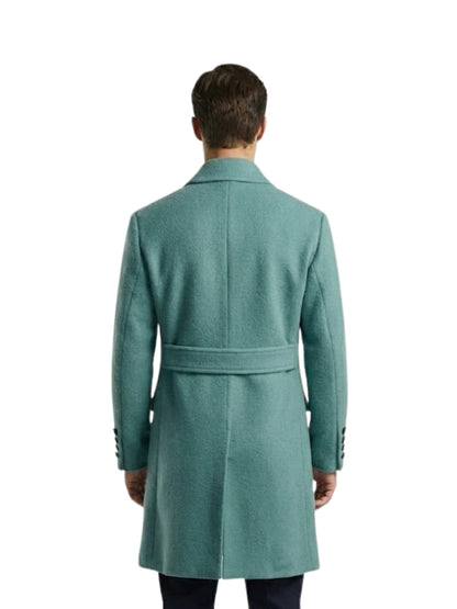 Man wearing a teal coat on a white background