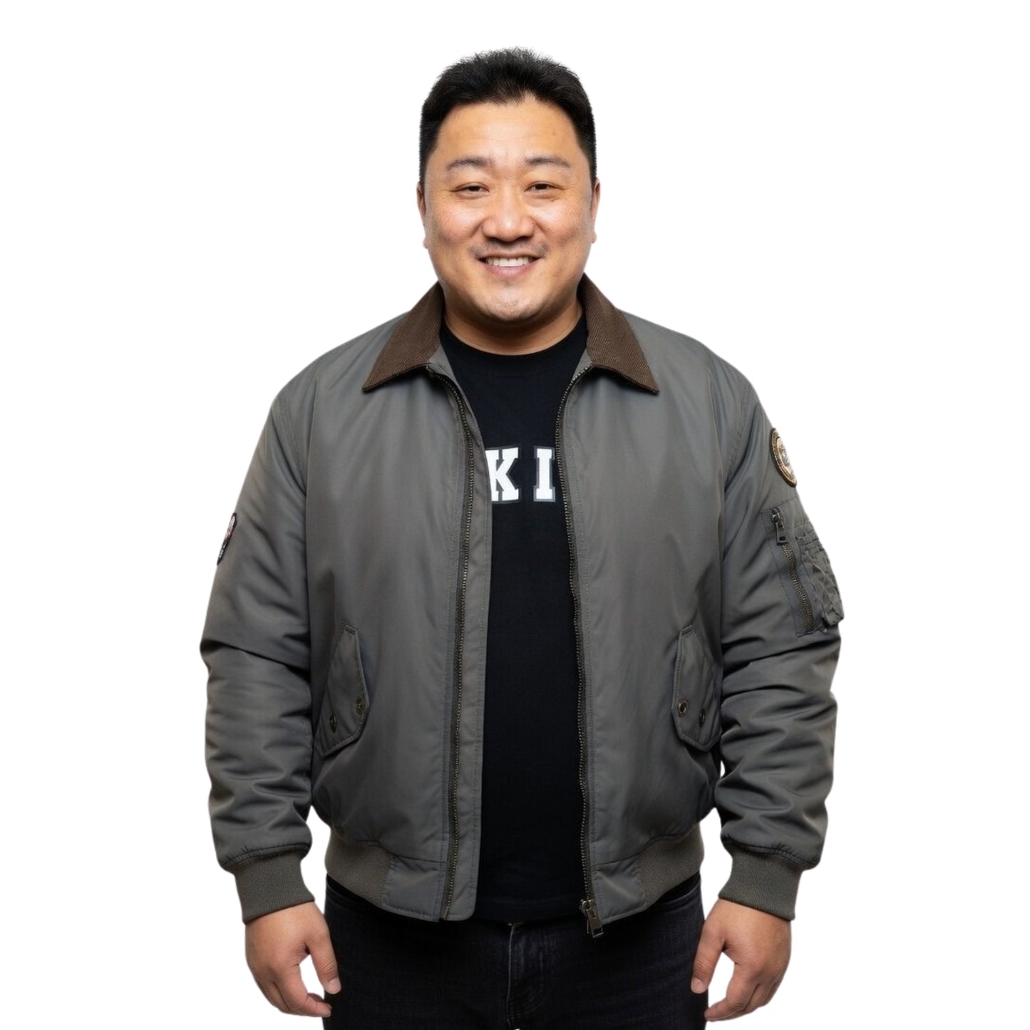 Man wearing a gray bomber jacket over a black shirt with visible branding on a white background
