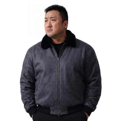 Man wearing a dark gray jacket with a black collar on a white background