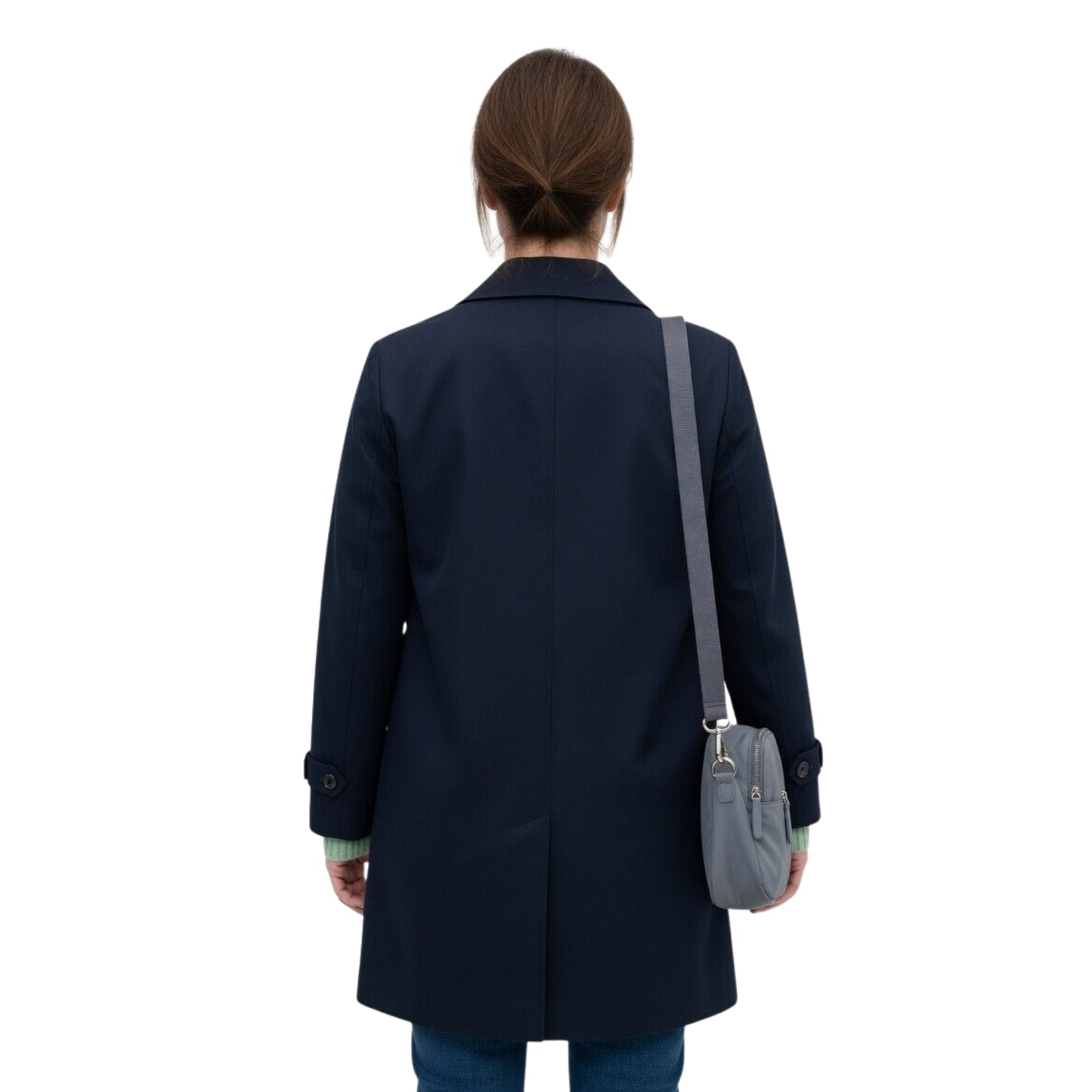 Person wearing a navy coat with a gray bag on a white background