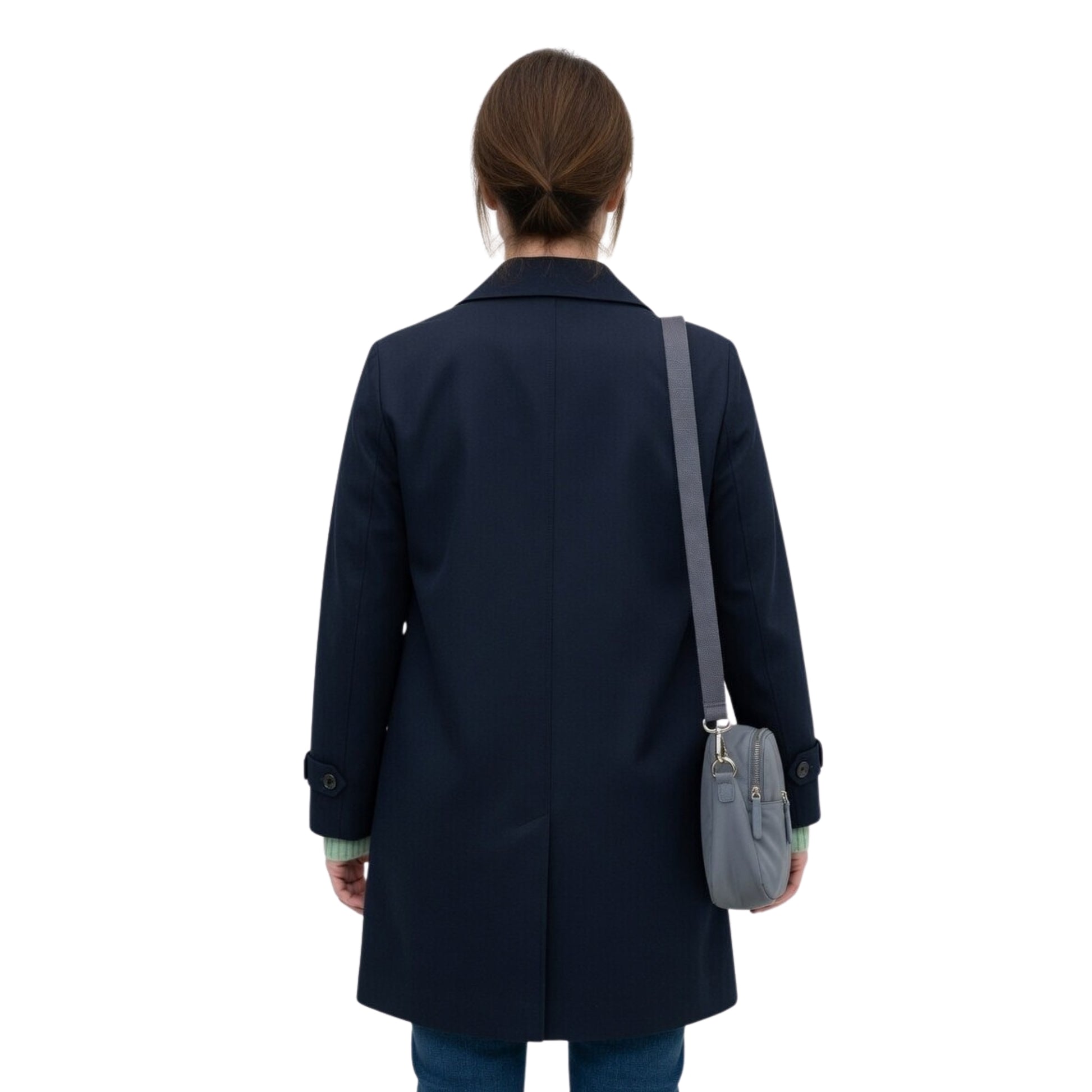 Person wearing a navy coat with a gray bag on a white background