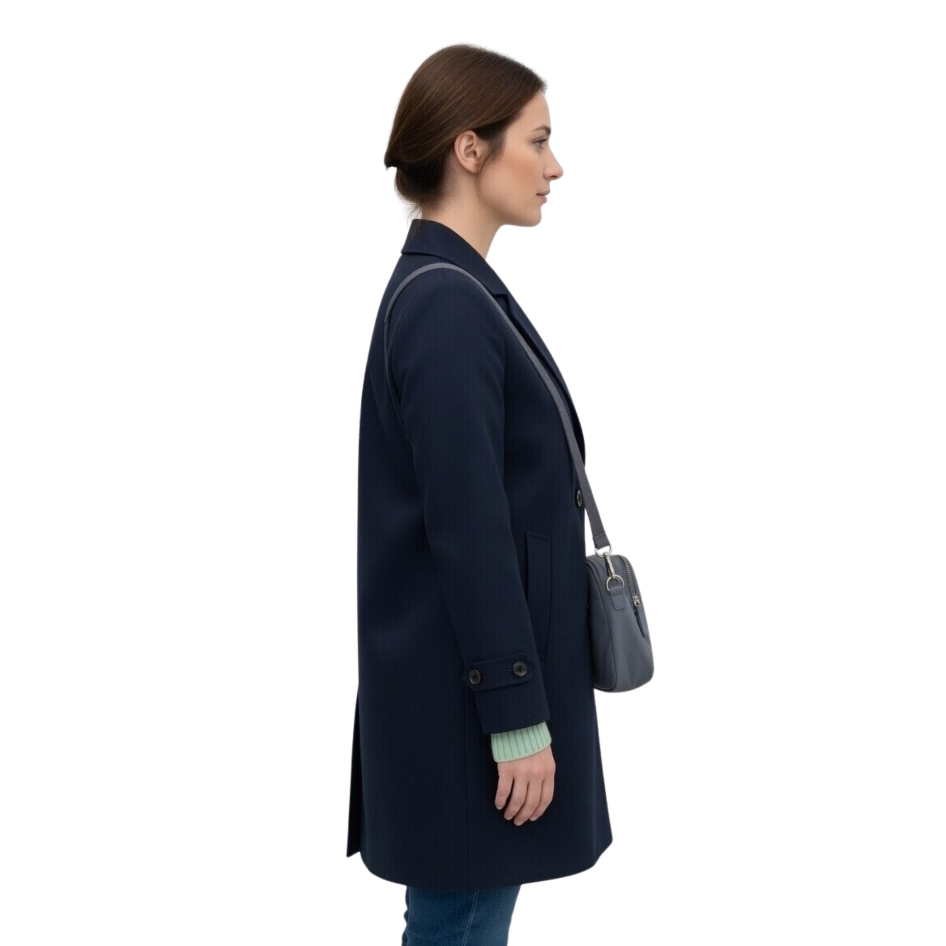 Woman wearing a navy coat holding a gray handbag on a white background
