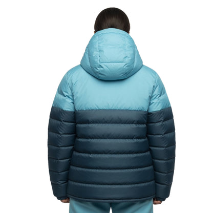 Back view of a person wearing a two-tone blue puffer jacket on a white background