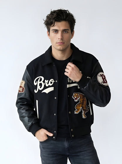 Man wearing a black varsity jacket with patches on a white background