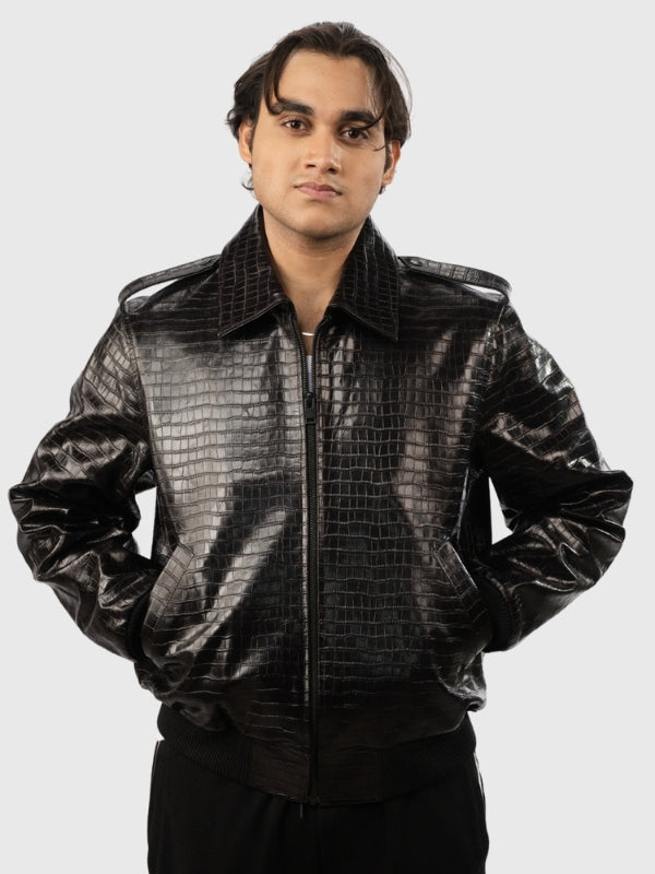 Person wearing a shiny black jacket with a textured pattern on a white background