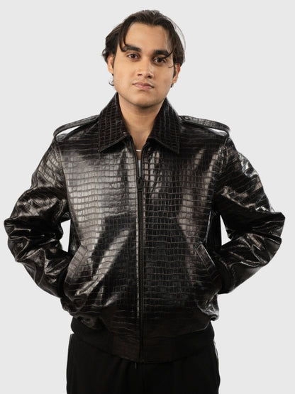 Person wearing a shiny black jacket with a textured pattern on a white background