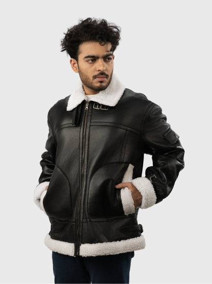 Man wearing a black leather jacket with white fur trim on a light gray background