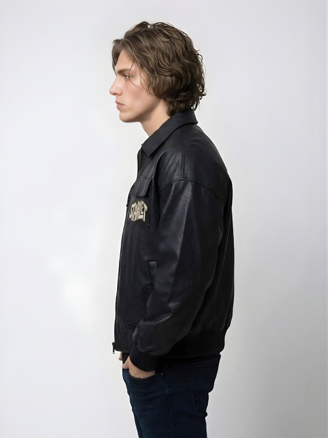 Person wearing a black leather jacket with a logo on a white background