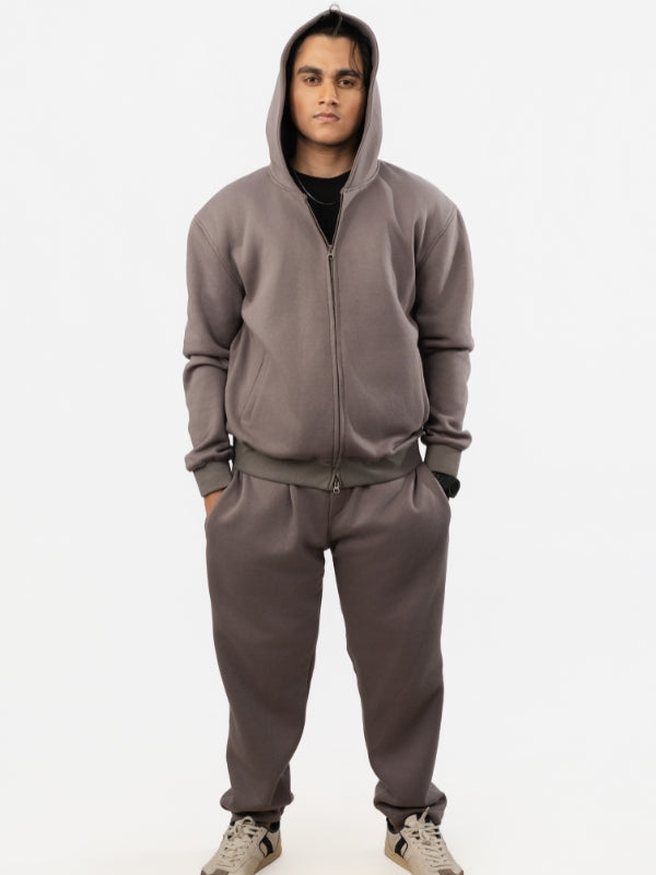Person wearing a gray tracksuit on a white background