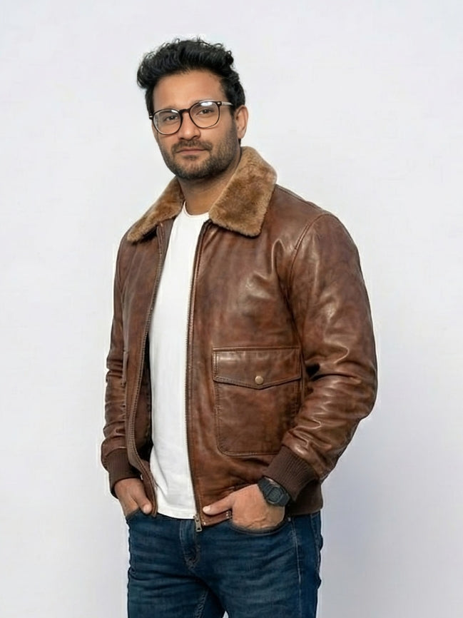 Man wearing a brown leather jacket with a fur collar on a white background
