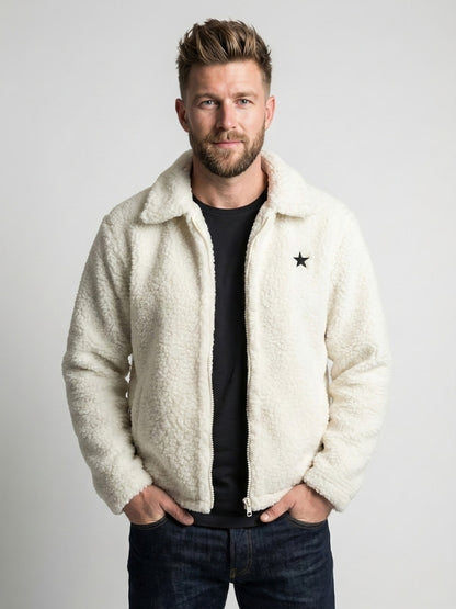 Man wearing a white sherpa jacket with a star logo on a plain background