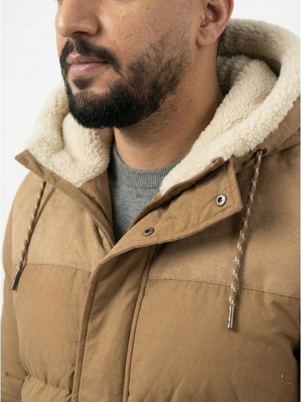 Close-up of a person wearing a brown puffer jacket with a fur-lined hood.