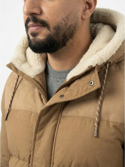 Close-up of a person wearing a brown puffer jacket with a fur-lined hood.