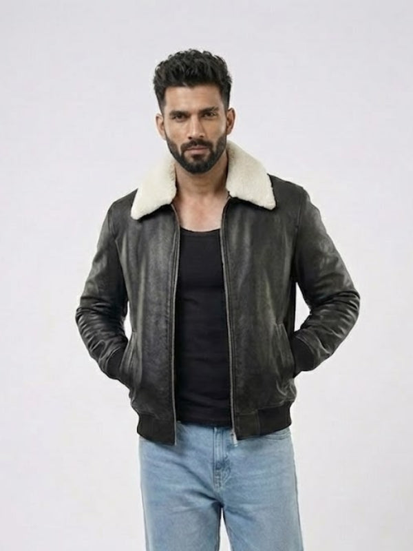 Man wearing a dark leather jacket with white fur lining on a light gray background