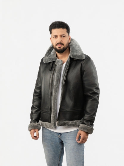 Man wearing a dark leather jacket with gray shearling collar and cuffs on a white background