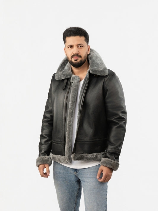 Man wearing a dark leather jacket with gray shearling collar and cuffs on a white background