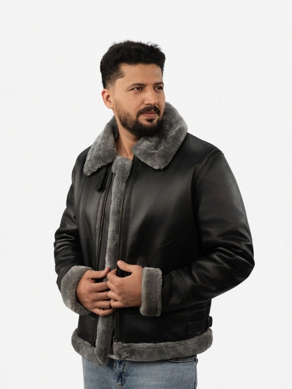 Man wearing a black leather jacket with gray fur lining on a white background