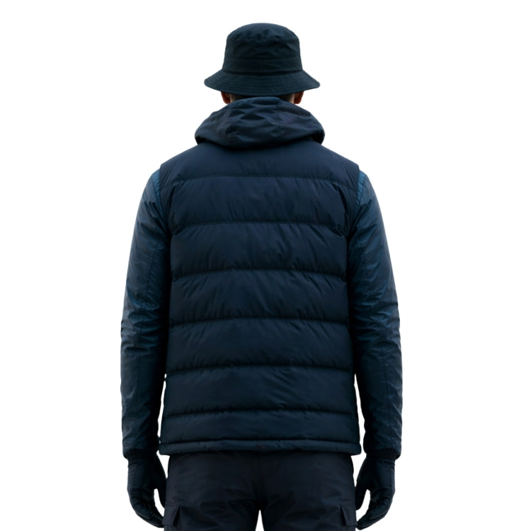 Person wearing a navy blue puffer jacket and hat on a white background