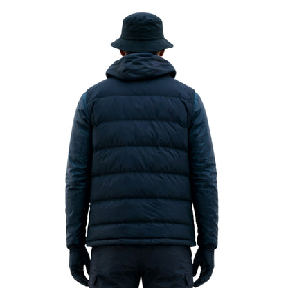 Person wearing a navy blue puffer jacket and hat on a white background