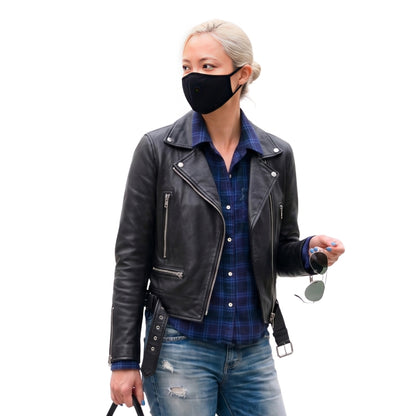 Person wearing a black leather jacket, plaid shirt, and jeans on a white background