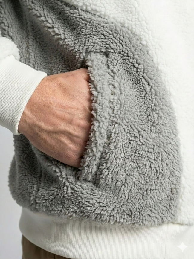 Close-up of a person wearing a gray fleece jacket with a white shirt underneath.