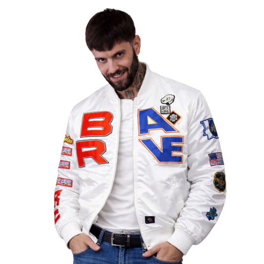 Man wearing a white bomber jacket with colorful text and patches on a white background