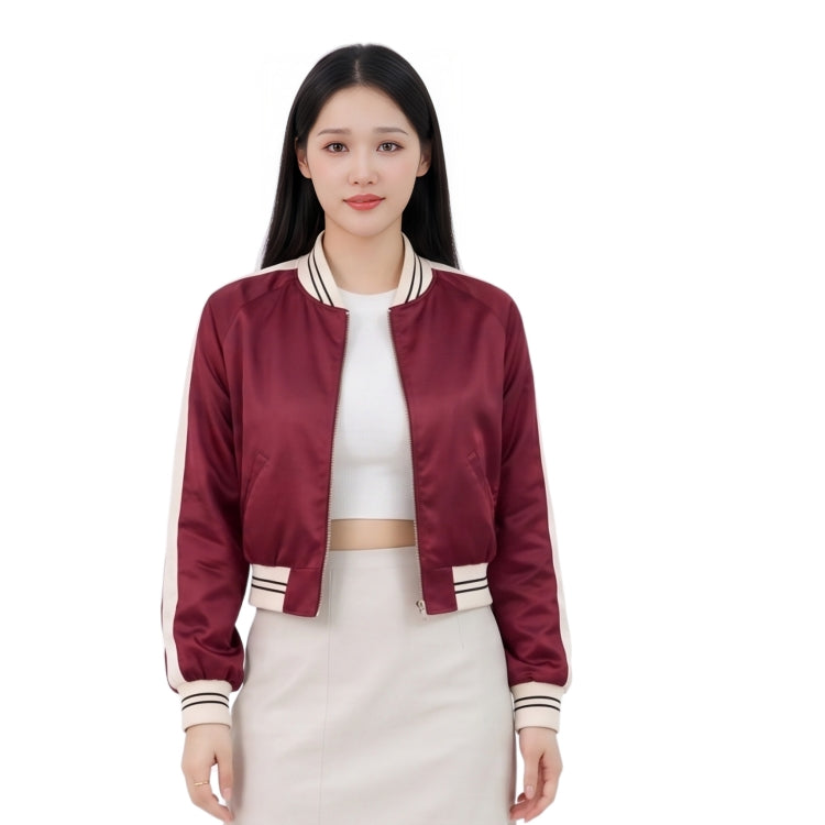 Woman wearing a maroon bomber jacket with white accents on a white background