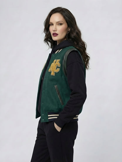 Woman wearing a green and black varsity jacket with a logo on a white background