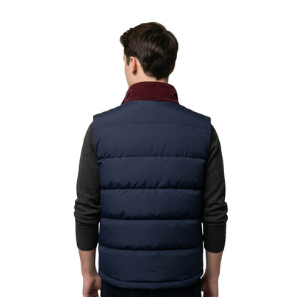 Person wearing a navy puffer vest over a dark shirt on a white background