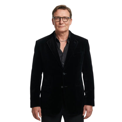 Man wearing a black velvet blazer on a white background