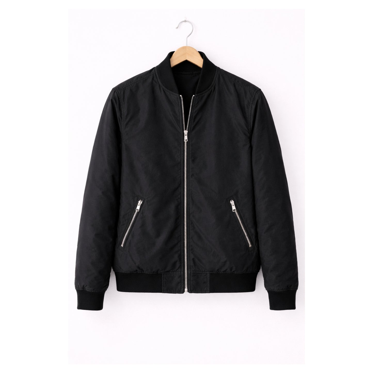 Black bomber jacket on a hanger against a white background