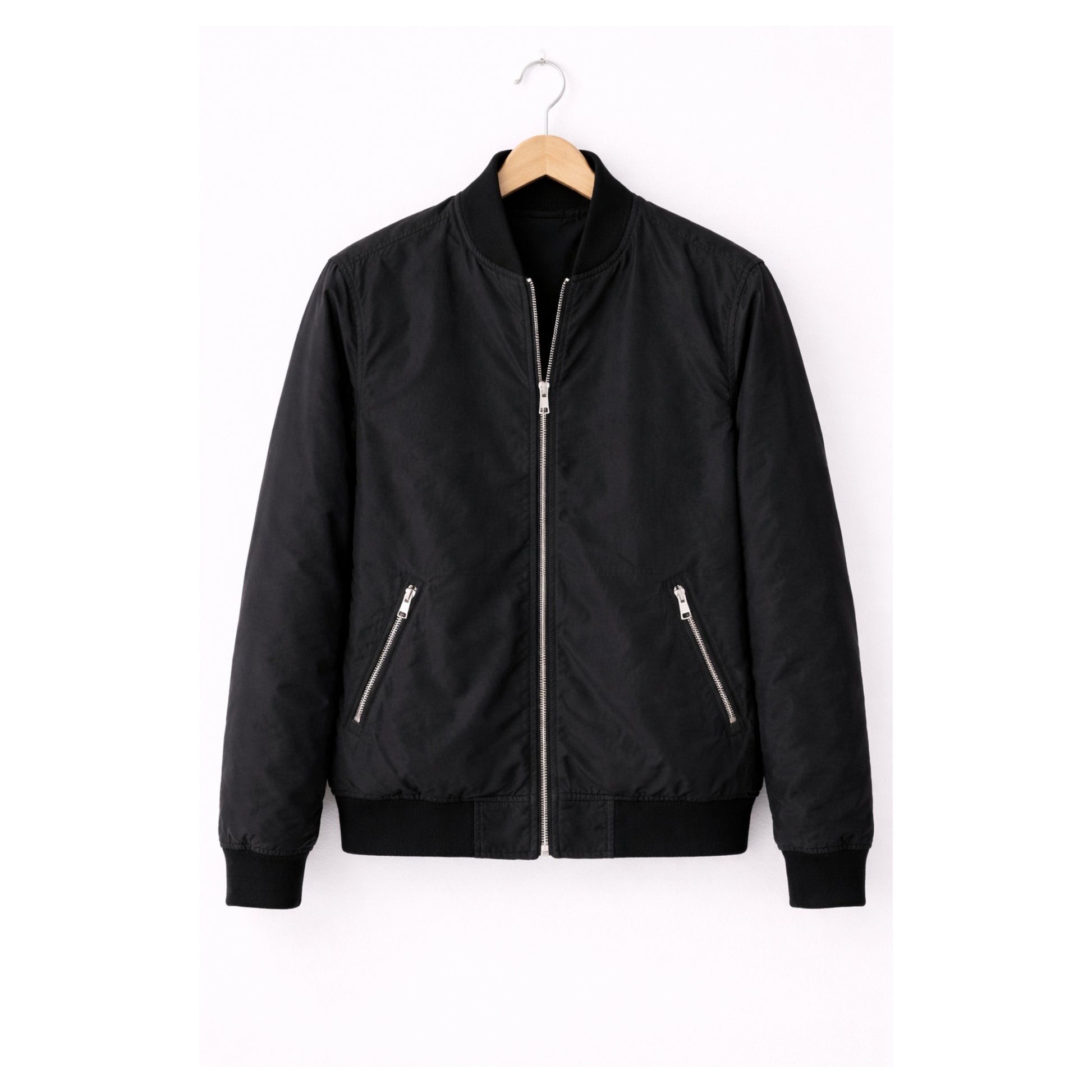 Black bomber jacket on a hanger against a white background
