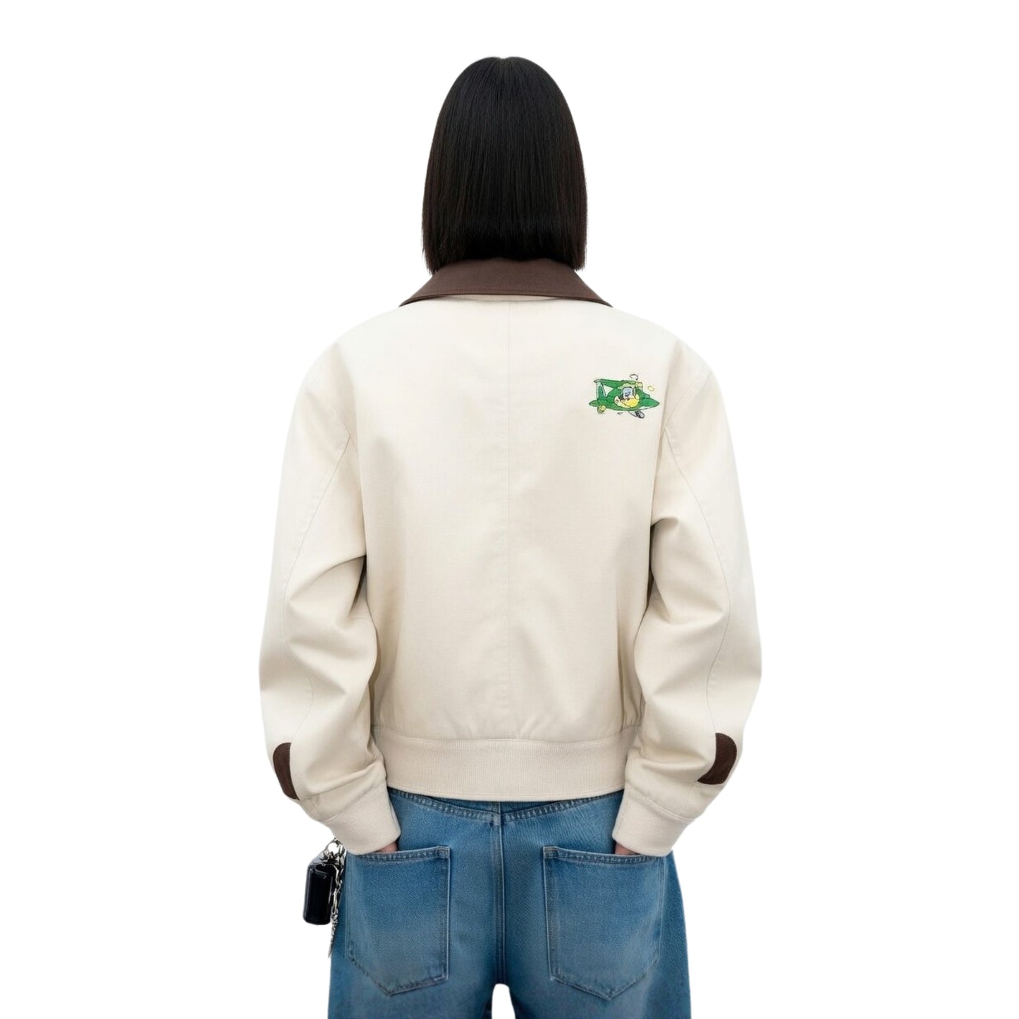 Person wearing a beige jacket with a logo on the back against a white background