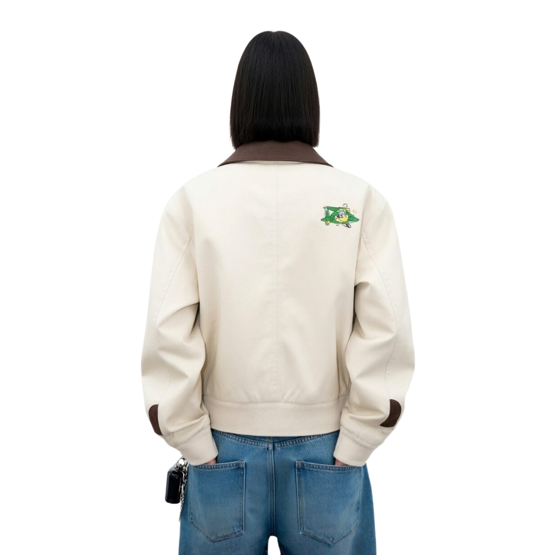 Person wearing a beige jacket with a logo on the back against a white background