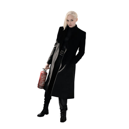 Person wearing a long black coat holding a red gas canister on a white background